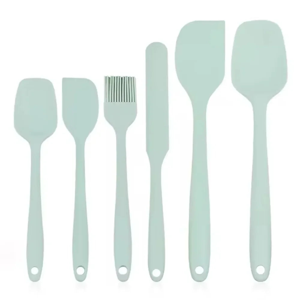 Mint green silicone kitchen utensil set with spatulas, brush, and scraper for cooking and baking