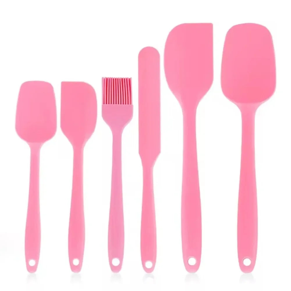 Pink silicone kitchen utensil set with spatulas, brush, and scraper for cooking and baking