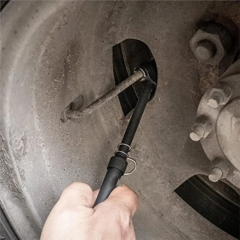 Hand installing heavy-duty trailer brake cable into wheel hub for safe towing